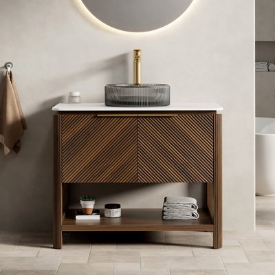 Meuble-lavabo autoportant avec comptoir en pierre frittée, vasque, armoire en contreplaqué, portes cannelées en diagonale, tablette ouverte et quincaillerie à fermeture en douceur.