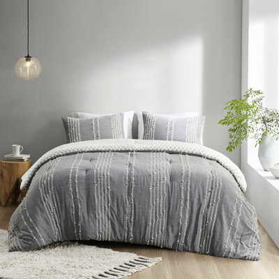 Lit double / grand en coton gris. 100% coton. Rayures brodées colorées. Revers gris avec imprimé. Édredon et 2 taies décoratives. Lavable à la machine. Gris. Tissu. Rayures sur fond gris. Taies décoratives assorties incluses.
