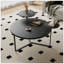 Table basse moderne avec deux tablettes, surfaces en faux marbre noir, base inspirée d'un trépied, bords de table arrondis