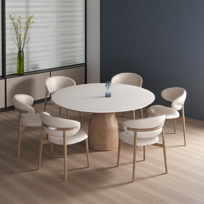Round stone slab breakroom tables, paired with four solid wood leather chairs.