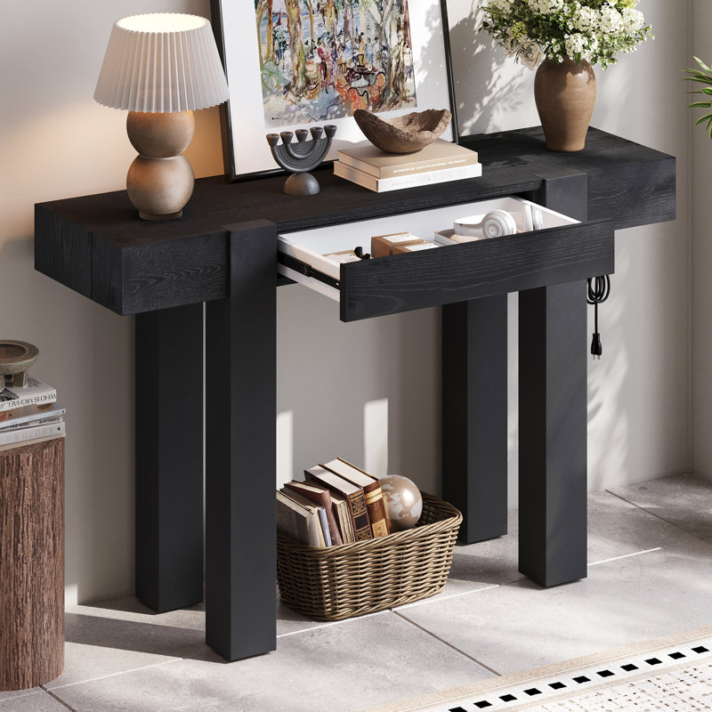 Table d'entrée en bois noir de style rustique et minimaliste, idéale pour le salon. Elle est munie d'un tiroir dissimulé et d'une prise électrique latérale. Montage en 30 minutes. Construction robuste et durable. Parfait pour un décor contemporain.