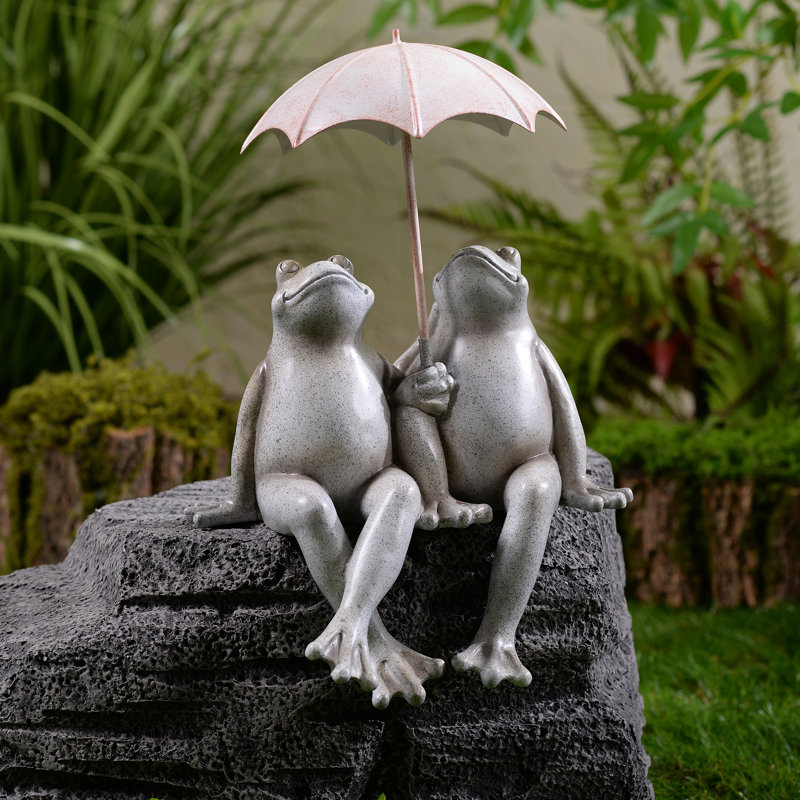 Statue de jardin assis avec quelques grenouilles et parasol