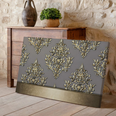 La toile crée un design de papier peint élégant avec un motif damassé complexe en or chatoyant contre un taupe doux