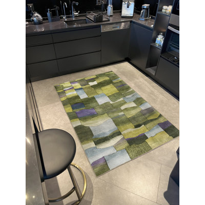 Tapis décoratif vert à motif géométrique multicolore