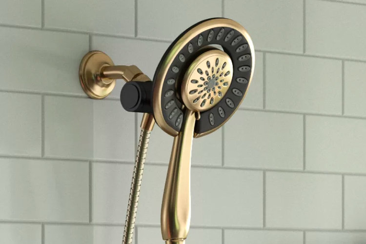 side view of a fixed brass showerhead against light green subway tile