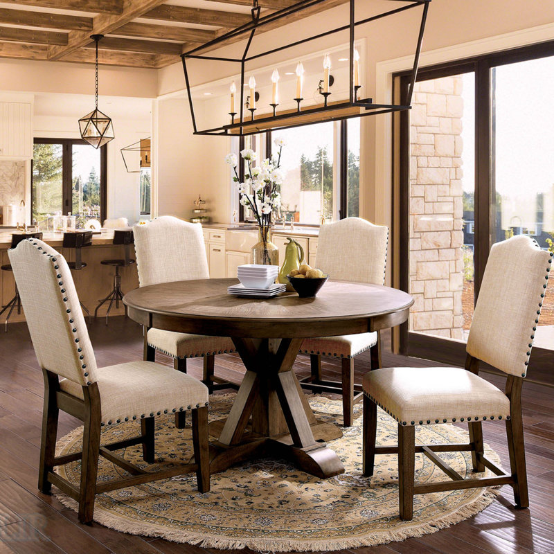 Ensemble de table de salle à manger rustique avec chaises en tissu beige, base à piédestal et garniture cloutée pour des repas élégants