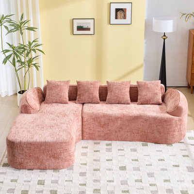 Pink Chenille L-Shaped Compressed Sofa That Goes Well With Any Living Room. It Features High-Elastic Sponge For A Comfortable Sitting Feel,  Curved Armrests And Four Throw Pillows.