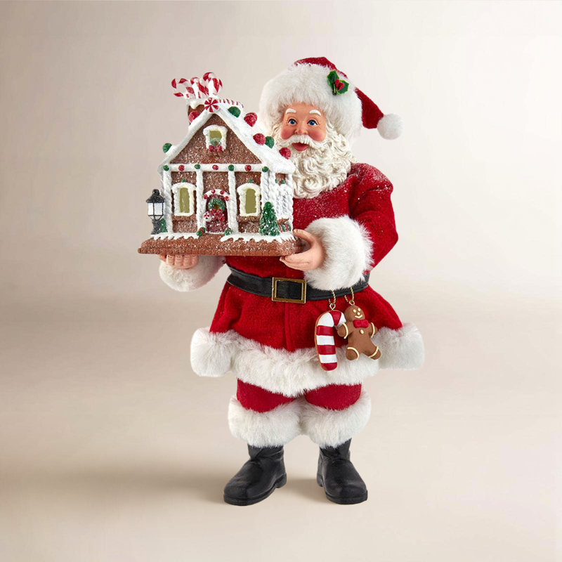 Père Noël avec maison de pain d'épices illuminée