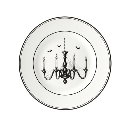 White salad plate with a black rim featuring a spooky, spiderweb-covered chandelier and flying bats in the center.