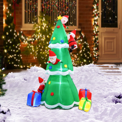 Père Noël grimpant à un arbre gonflable