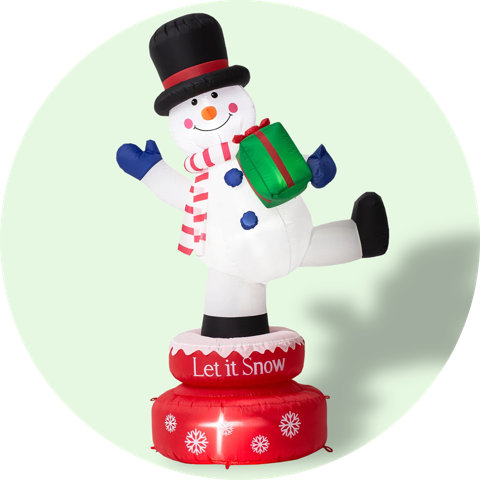 Inflatable snowman with present on a base that says Let it Snow.