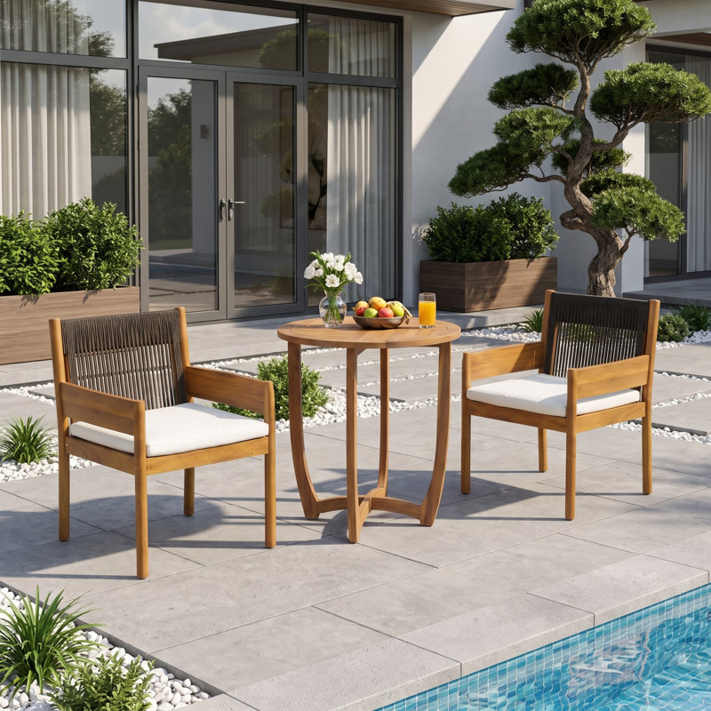 Ensemble bistro de patio Celia pour 2 personnes, style côtier moderne, en bois d'acacia, avec fauteuils à accoudoirs tressés, coussins et table ronde à lattes.