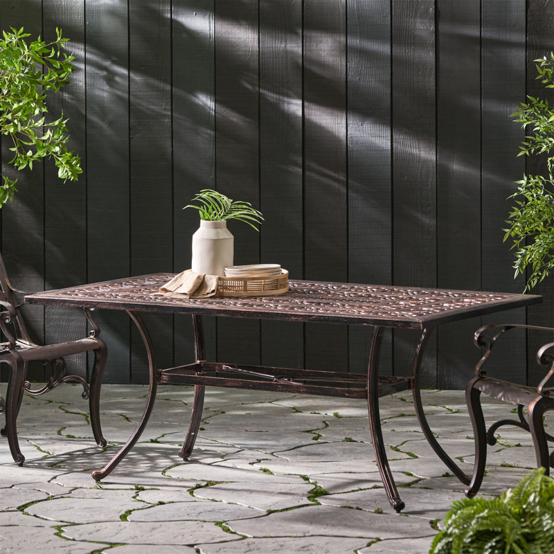 Table de salle à manger d'extérieur en fonte d'aluminium avec motif floral coupé dans une teinte cuivrée