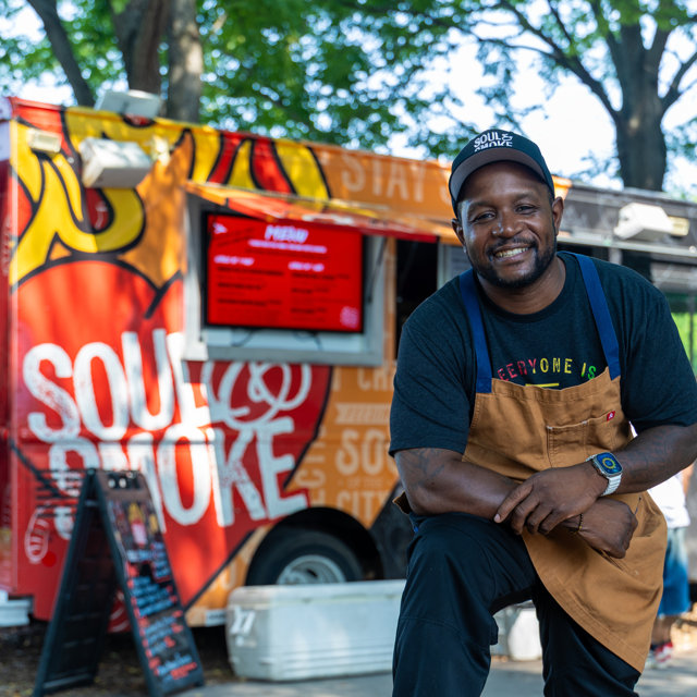 Smiling chef in front of Soul & Smoke food truck, stay hungry.