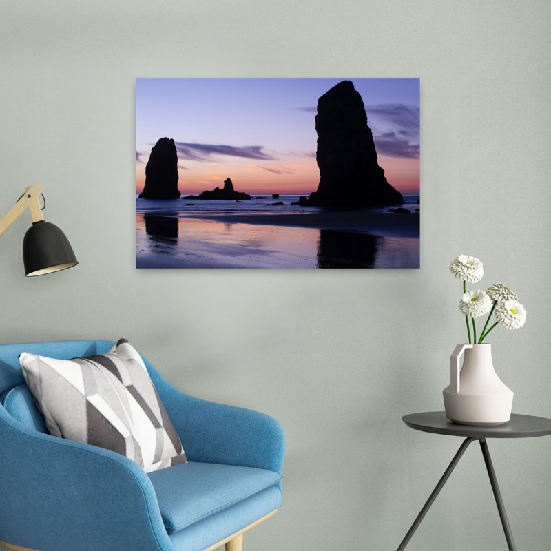 Silhouettes Of Rock Formations At Sunset At Cannon Beach Oregon USA by Dan Merkel - Wrapped Canvas Print