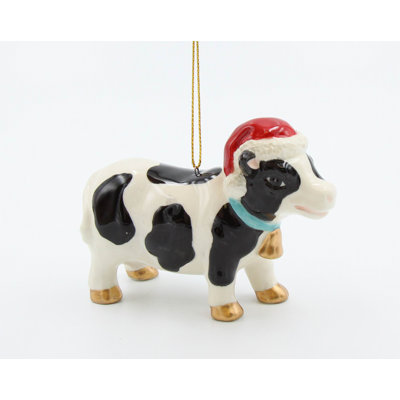Vache portant un ornement de Noël suspendu à un chapeau de Noël