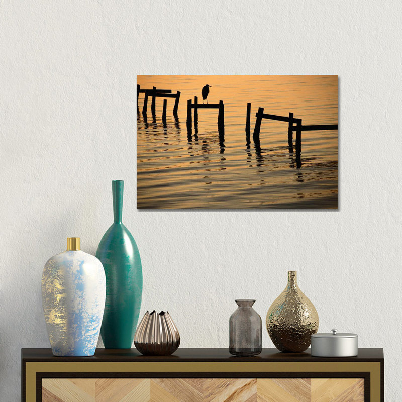 A Silhouetted Heron Perches On The Pilings Of An Old Dock by Joel Sartore - Gallery-Wrapped Canvas Giclée on Canvas, Canvas