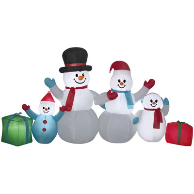 Scène familiale de Noël avec bonhomme de neige gonflable avec cadeaux
