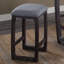 Tabouret invitant à hauteur de comptoir en tissu gris et patiné