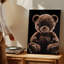 Toile, un ours en peluche moelleux repose sur un fond d'art mural noir profond qui évoque une présence chaleureuse et invitante-744615624