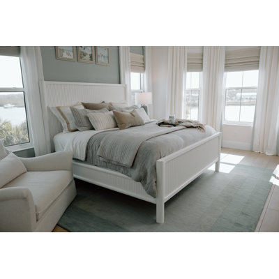 Luxurious Solid Mahogany Wood Queen Bed in Pristine White with Laser-Cut Finish, Intricate Reeded Design, Rounded Bedposts, Modern Style, and Tech-Ready Nightstand Featuring Integrated Power and USB Outlets for a Timeless Coastal Retreat