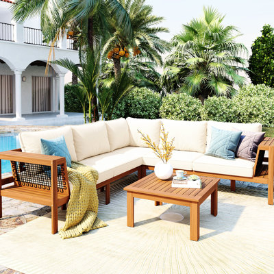 Ensemble de jardin 4 pièces en bois avec canapé d'angle en L, coussins gris en maille tissée, table basse et structure stable pour terrasse. Combinaison de matériaux.