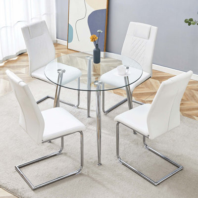 Une table ronde minimaliste moderne en verre trempé transparent avec des pieds en métal argenté et 4 chaises de salle à manger modernes en cuir d'unité centrale pour une expérience luxueuse.