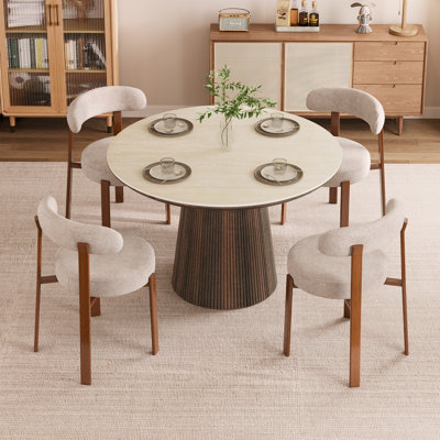 Ensemble de table et de chaises Adwin pour 4 personnes, comprenant une table ronde en pierre frittée de 120 cm et 4 chaises rembourrées.