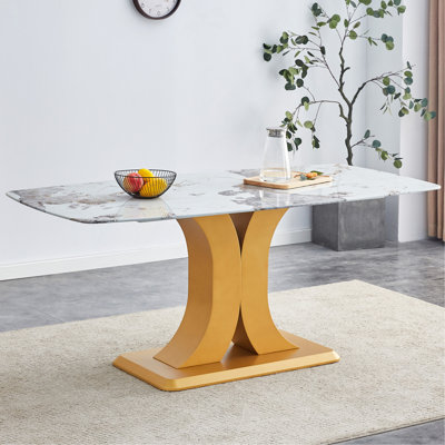 Une table de salle à manger minimaliste moderne. Plateau de table imitation verre marbré. Pieds de table en panneau de fibres à densité moyenne dorés pour la cuisine et le salon