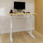Bureau multifonctionnel à hauteur réglable, levage manuel, structure en bois et en fer, support stable, adapté à divers espaces de travail. Bureau avec mécanisme, matériaux, double colonne permettant différentes postures.