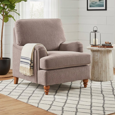 Fauteuil en tissu Candor avec accoudoirs roulés anglais, coussins rembourrés et pieds en bois massif pour un confort et un style intemporels.