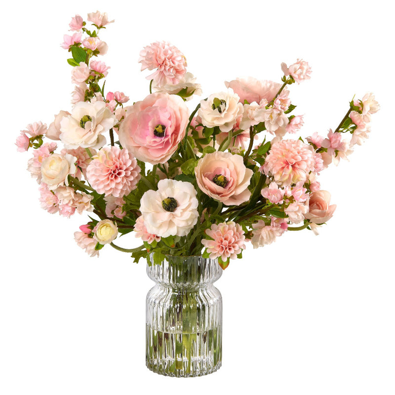 Bouquet de renoncules et fleurs de cerisier dans un vase en verre