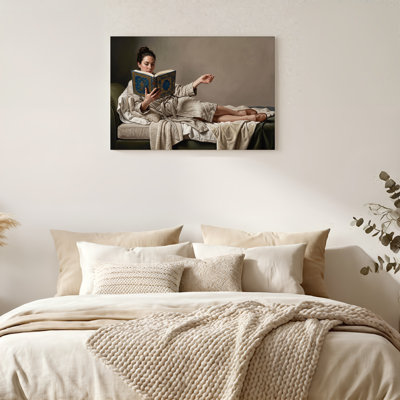 Woman Reading Ornate Blue Book on Green Sofa Canvas Wall Art