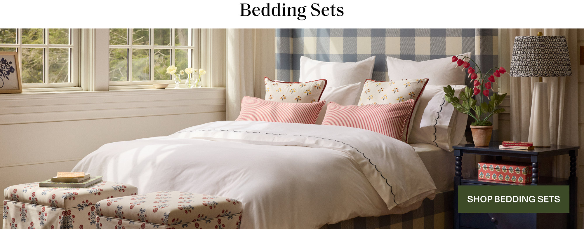 Bedding Sets featuring a blue and white buffalo check headboard with a layered white comforter and decorative floral and striped accent pillows. Shop Bedding Sets.