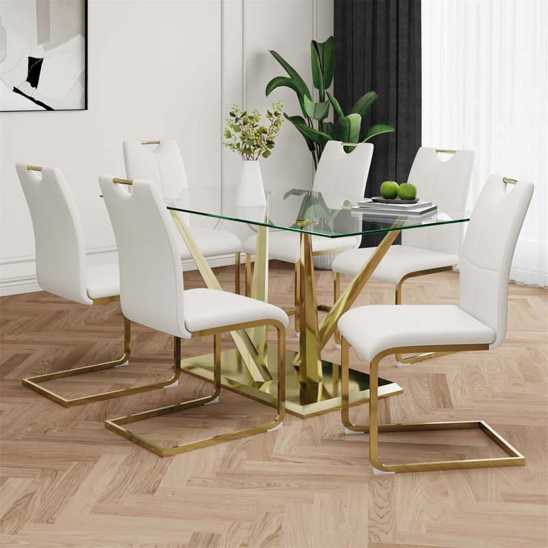 Table de salle à manger moderne en verre avec design transparent et base en acier inoxydable, ensemble de chaises blanches avec pieds plaqués or
