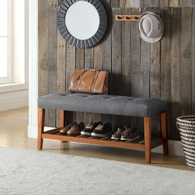 Banc en tissu gris et finition chêne avec siège capitonné et tablette de rangement, parfait pour les salons modernes et les vestibules.