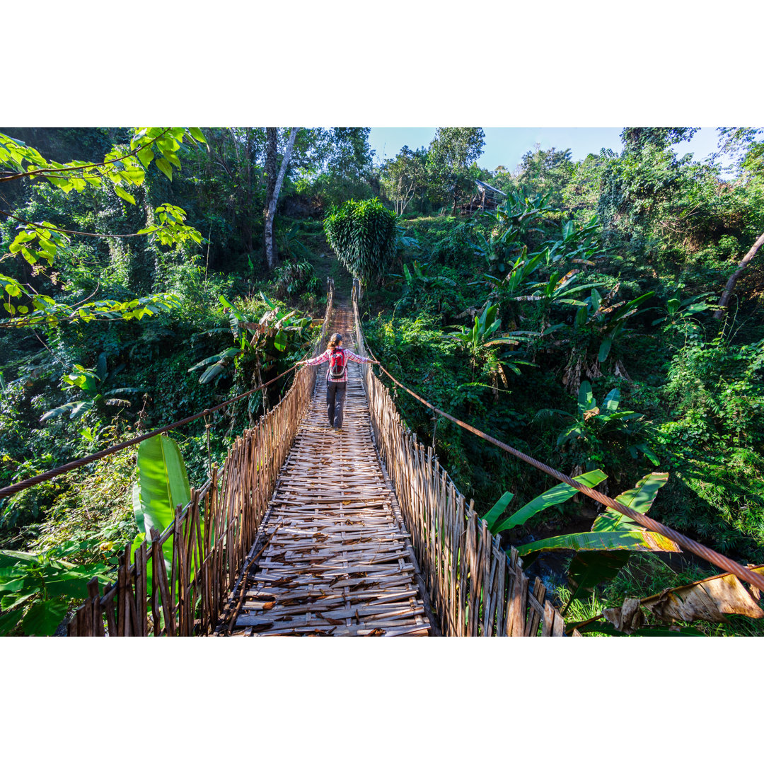 Frau mit Rucksack auf Hängebrücke im Regenwald von FredFroese - No Frame Print on Canvas