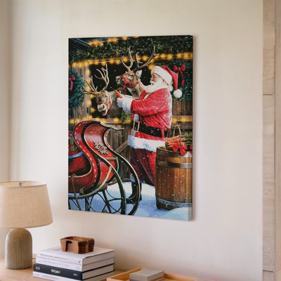 Toile «Jolly figure in a Classic Red Santa suit», art mural complet avec garniture de fourrure blanche qui interagit joyeusement avec deux rennes