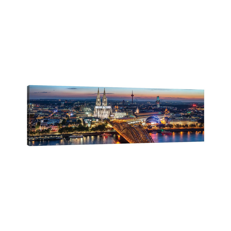 Aerial View Of Cologne With Cologne Cathedral And Hohenzollern Bridge At Night by Jan Becke - Wrapped Canvas Panoramic Print