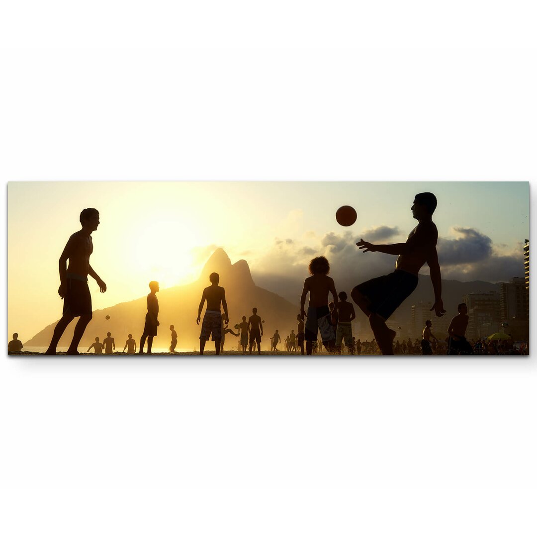 Leinwandbild Fußball im Sonnenuntergang