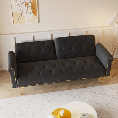 Un canapé-lit de 69,7 pouces de long recouvert de velours noir, avec garniture cloutée et accompagné d'un coussin décoratif assorti