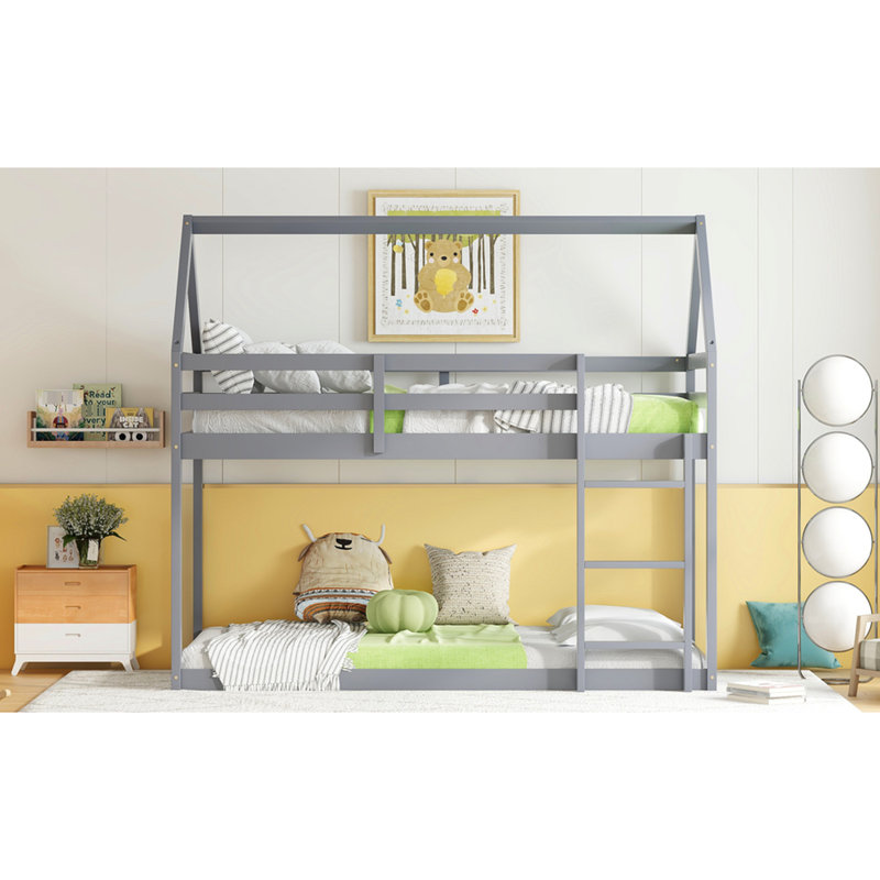 Lit simple gris au-dessus d'un lit en bois d'hévéa gris, avec une caractéristique fascinante en forme de maison et des barrières de sécurité en forme de maison