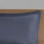Édredon simple avec draps à rayures bleu gris et oreiller - calme et literie pour une chambre à coucher