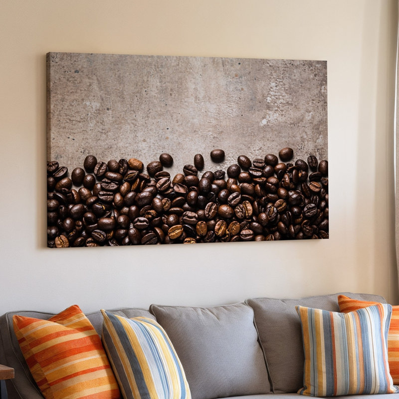 Toile, composition en gros plan avec un art mural sombre et dispersé de grains de café bruns disposés avec art le long du bord inférieur
