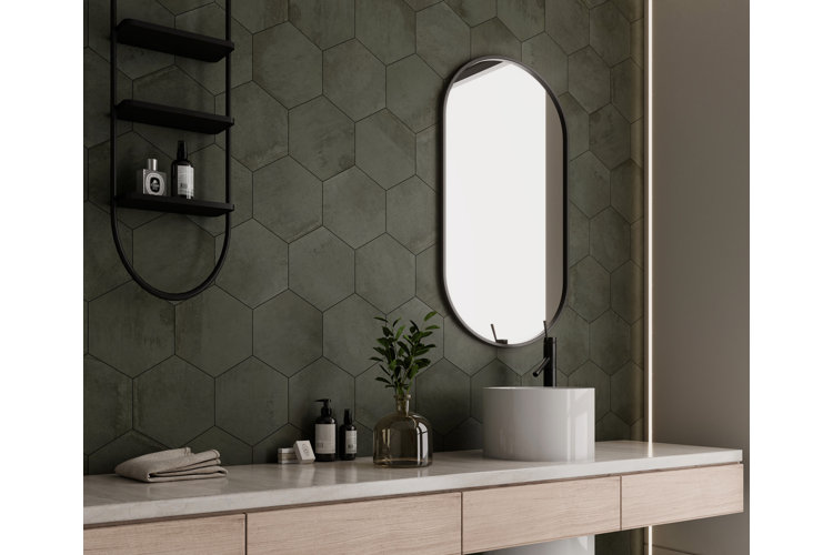 gray hexagonal wall tile on backsplash behind a bathroom vanity. oval wall mirror next to an oval wall shelf