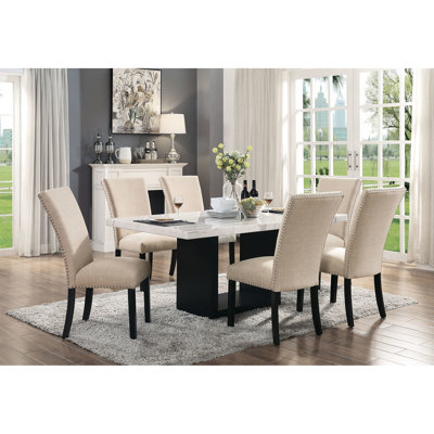 Ensemble de salle à manger 7 pièces : table rectangulaire en marbre et 6 chaises d'appoint beiges rembourrées, design fonctionnel de style transitionnel, avec assises en tissu ornées de clous décoratifs.