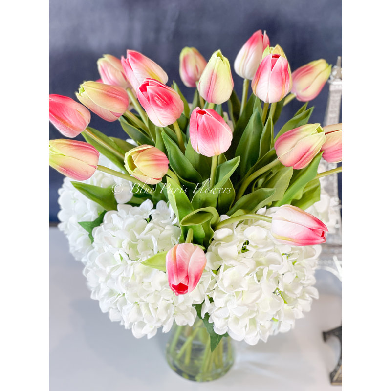 Vraies tulipes et hortensias dans un vase en verre