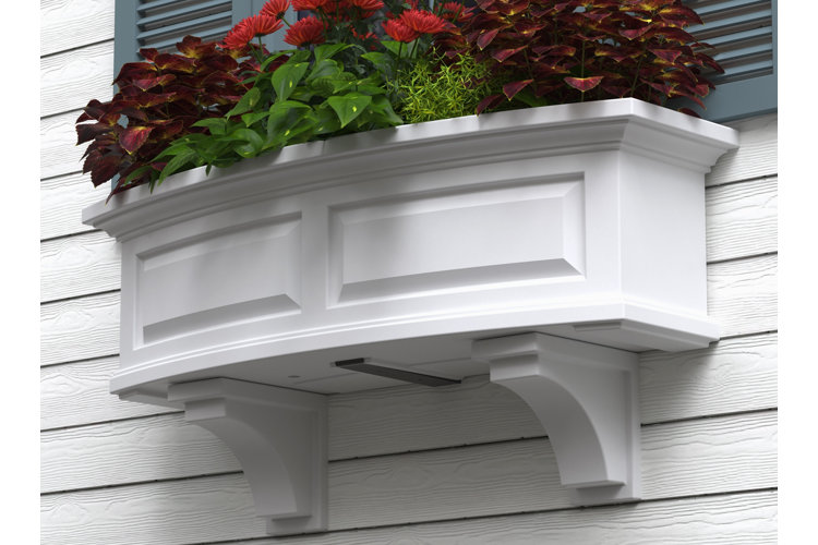 two white corbels supporting a window box of flowers