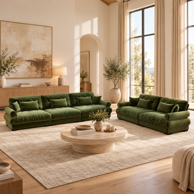 Ensemble de salon composé d'un canapé sculptural 5 places et d'une causeuse en velours vert avec coussins décoratifs