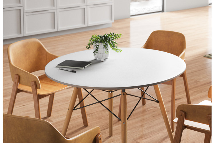Round dining table with wood legs and four wood dining chairs.